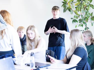 Elever taler sammen i klassen.