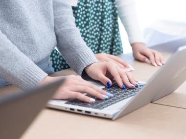 Pige taster på sin bærbare pc