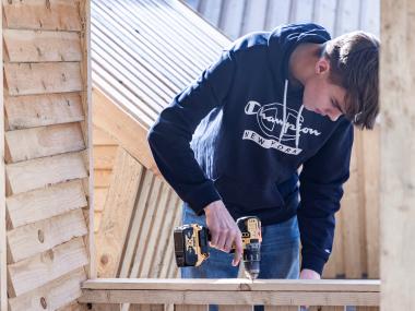Dreng skærer i træ